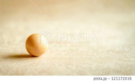 Small smooth wooden bead resting on light background 121172016