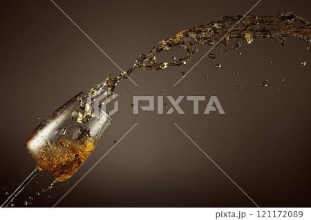 Glass and white wine splash on a beige background. Glass and white wine splash on a beige background. 121172089