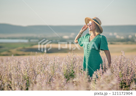 Woman Dress Field: Summer Fashion Photo Shoot; Blond woman in teal dress enjoys a sunny day in a lavender field. Woman Dress Field: Summer Fashion Photo Shoot; Blond woman in teal dress enjoys a sunny day in a lavender field. 121172904