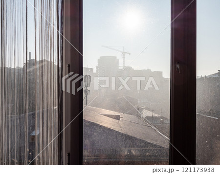 view through home window glass on city in smog 121173938