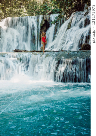 Woman in red swimwear on cascade waterfalls in Central Sulawesi Woman in red swimwear on cascade waterfalls in Central Sulawesi 121173975