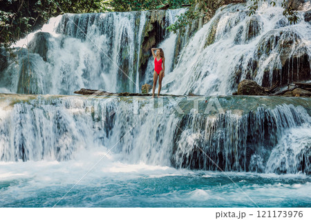 Woman on cascade waterfalls with blue water in Luwuk, Central Sulawesi Woman on cascade waterfalls with blue water in Luwuk, Central Sulawesi 121173976