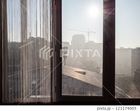 view through window of apartment on city in smog 121174005