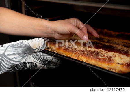 Carefully Checking the Perfectly Baked Dish with a Toothpick to Ensure its Just Right 121174794