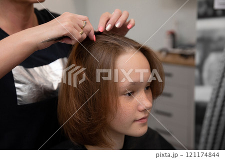 A Young Girl is Enjoying a Stylish Haircut at a Trendy Beauty Salon for Her New Look A Young Girl is Enjoying a Stylish Haircut at a Trendy Beauty Salon for Her New Look 121174844