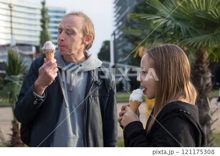 Joyful family. Cute child and father walking and enjoying ice cream at sunny day.  121175308