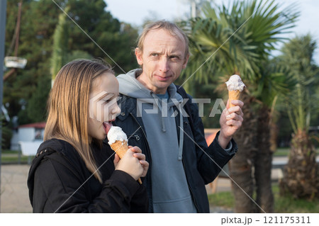 Happy child and father walking and enjoying ice cream at sunny day. Happiness and memory moment Happy child and father walking and enjoying ice cream at sunny day. Happiness and memory moment 121175311