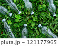Three plastic bottles with a green recycling symbol on a wooden surface 121177965