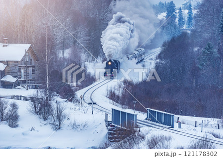 Retro steam train moves at winter morning. 121178302