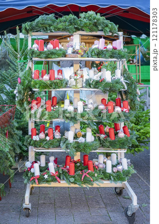 Festive market stall featuring Christmas wreaths with red and white candles, holiday decorations 121178303