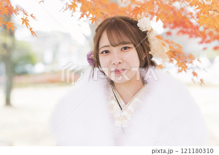 成人式前撮りイメージ　紅葉の中に立つ着物姿の女性 121180310