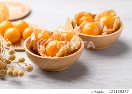 Cape gooseberry or Golden berry (Physalis peruviana) in wooden bowl on white background 121180377