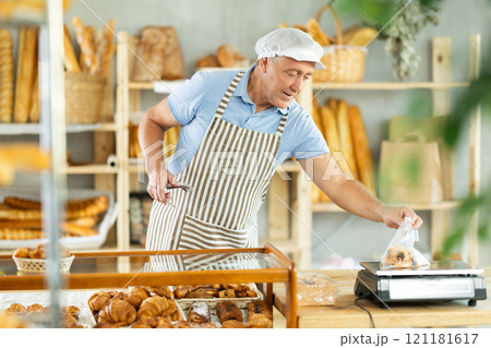 Elderly male seller puts pastries in bags and weighs 121181617