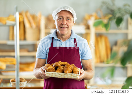 Elderly man seller with basket of croissants 121181620