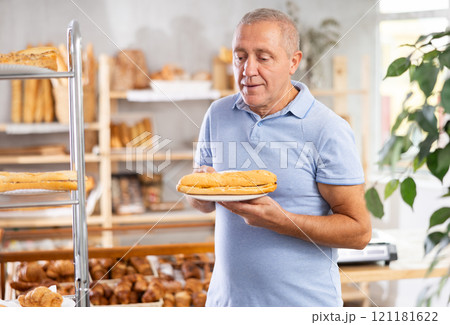 Elderly man with bocadillo sandwich in bakery 121181622