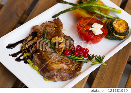 Roasted veal steak with guacamole on wooden surface 121181939