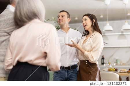 Joyful woman introducing boyfriend to elderly parents at home 121182271