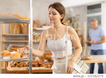 Young woman buyer chooses pastries in bakery Young woman buyer chooses pastries in bakery 121182278