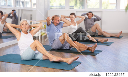 Elderly woman doing pilates in group Elderly woman doing pilates in group 121182465