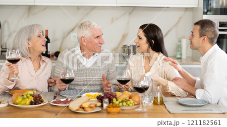 Elderly parents with daughter and son-in-law enjoying dinner 121182561
