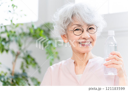 ペットボトルの水を飲むシニア女性 ペットボトルの水を飲むシニア女性 121183599