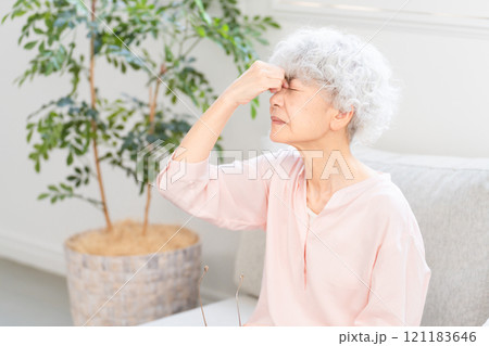 目頭を押さえるシニア女性 121183646