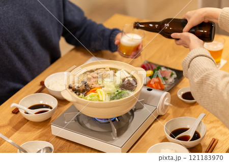 冬の夜のリビングで夕食の鍋料理を楽しむミドル夫婦 冬の夜のリビングで夕食の鍋料理を楽しむミドル夫婦 121183970