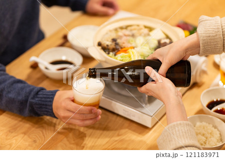 冬の夜のリビングで夕食の鍋料理を楽しむミドル夫婦 冬の夜のリビングで夕食の鍋料理を楽しむミドル夫婦 121183971