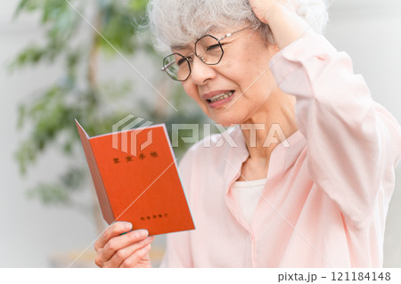 年金手帳を確認するシニア女性 121184148