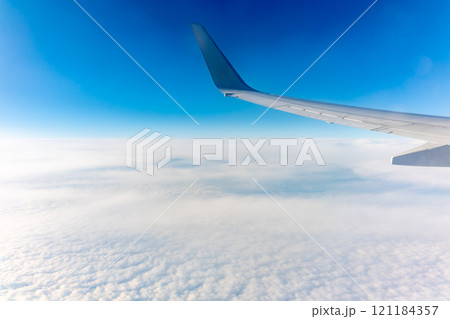 View from the airplane window at a beautiful cloudy sky and the airplane wing View from the airplane window at a beautiful cloudy sky and the airplane wing 121184357