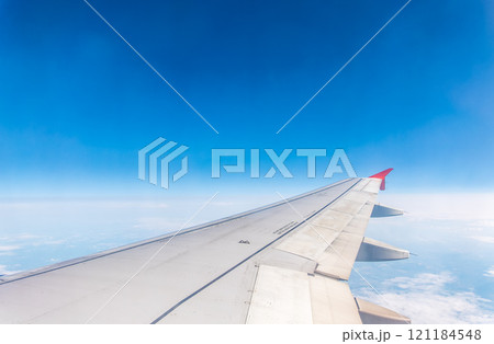 View from the airplane window at a beautiful cloudy sky and the airplane wing 121184548