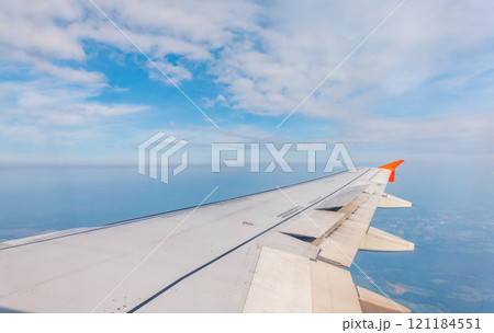 View from the airplane window at a beautiful cloudy sky and the airplane wing 121184551