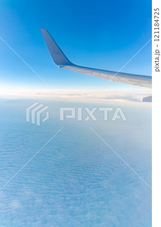 View from the airplane window at a beautiful cloudy sky and the airplane wing View from the airplane window at a beautiful cloudy sky and the airplane wing 121184725