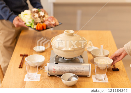 冬の夜のリビングで夕食の鍋料理の準備をするミドル夫婦 冬の夜のリビングで夕食の鍋料理の準備をするミドル夫婦 121184845