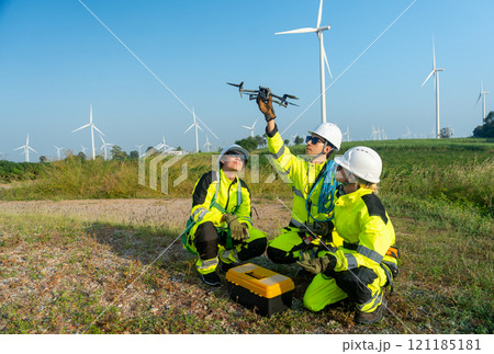 Side view group of wind turbine or windmill workers or technician check for preparing to use drone in workplace field. Side view group of wind turbine or windmill workers or technician check for preparing to use drone in workplace field. 121185181