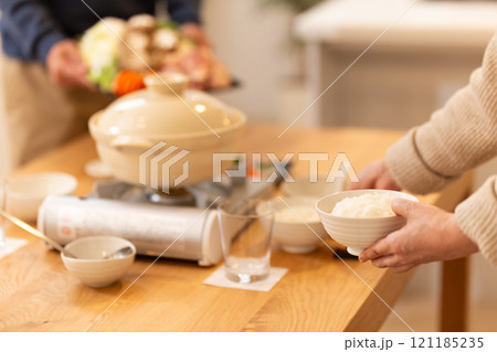 冬の夜のリビングで夕食の鍋料理の準備をするミドル夫婦 冬の夜のリビングで夕食の鍋料理の準備をするミドル夫婦 121185235