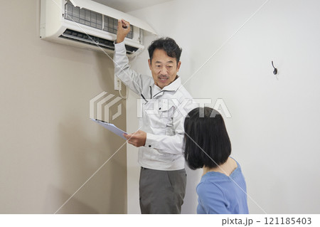 エアコンの故障をチェックをする業者の作業員 121185403