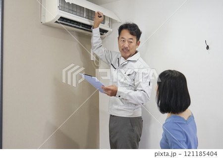 エアコンの故障をチェックをする業者の作業員 121185404