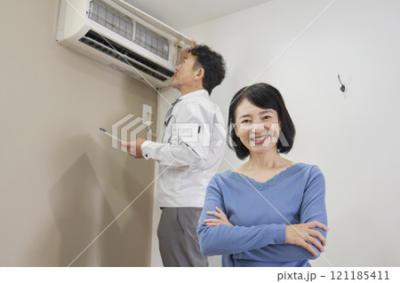エアコンの故障の修理に安心する女性 エアコンの故障の修理に安心する女性 121185411