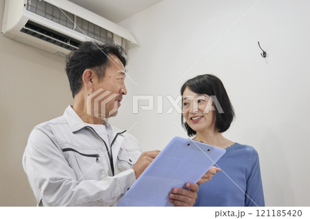 エアコンの修理の見積もりに喜ぶ女性 エアコンの修理の見積もりに喜ぶ女性 121185420