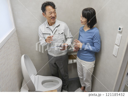 トイレの故障の修理を修理業者に依頼する女性 トイレの故障の修理を修理業者に依頼する女性 121185432