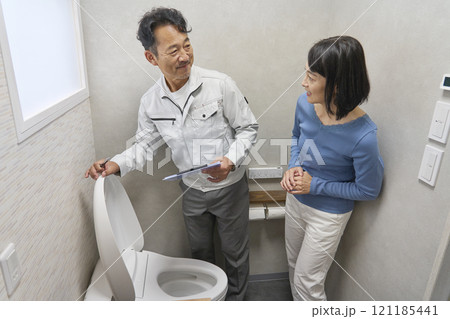 トイレの故障の修理を修理業者に依頼する女性 トイレの故障の修理を修理業者に依頼する女性 121185441