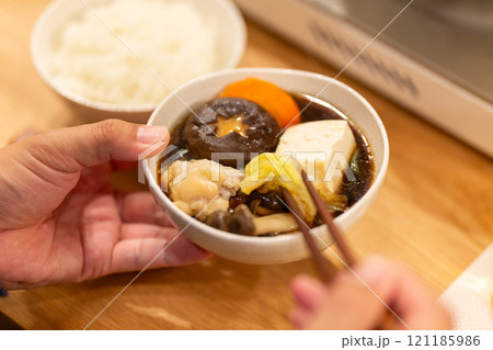 冬の夜のリビングで夕食の鍋料理を楽しむ男性の手元 121185986