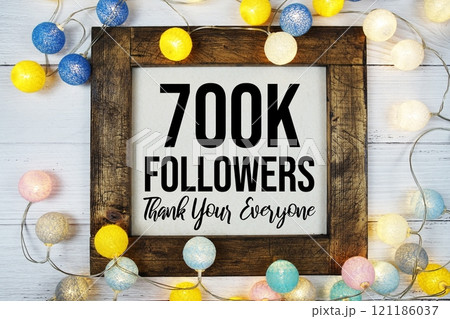 Thanks You 700000, 700K Followers text written on blackboard with LED cotton balls decoration on wooden background Thanks You 700000, 700K Followers text written on blackboard with LED cotton balls decoration on wooden background 121186037