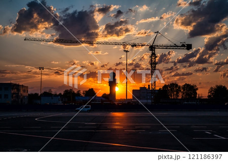 Tower crane on the background of a picturesque sunrise in an empty airport 121186397