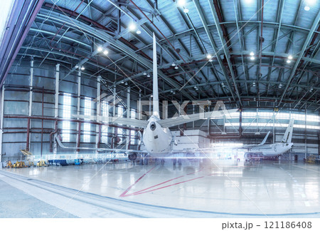 Passenger aircrafts under maintenance. Checking mechanical systems for flight operations. Panorama of airplanes in the hangar Passenger aircrafts under maintenance. Checking mechanical systems for flight operations. Panorama of airplanes in the hangar 121186408