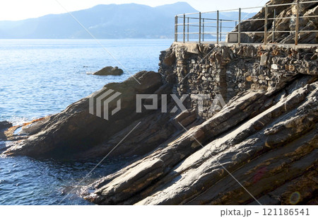 Sea and rock with walkway for tourists. Panorama and relaxation. Sunny day and calm.  121186541