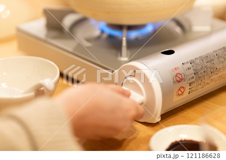 カセットコンロの火をつけるミドル女性の手 カセットコンロの火をつけるミドル女性の手 121186628