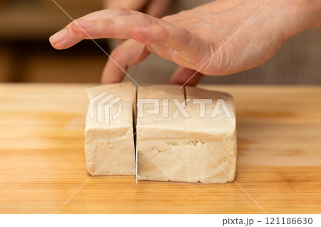 まな板で木綿豆腐を切るミドル女性の手元 まな板で木綿豆腐を切るミドル女性の手元 121186630