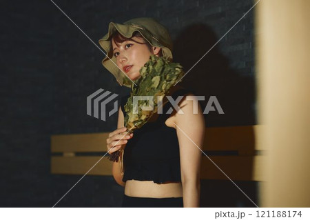 サウナでヴィヒタを使う女性　撮影協力・白玉の湯 泉慶 121188174